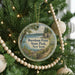 A circular ornament hanging on a Christmas tree, featuring a scenic image of Burnham Point State Park in New York.
