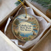 A decorative ornament in a box, featuring a scenic landscape with a lake, mountains, and a goat.