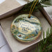 A decorative ornament in a box, featuring a scenic image of Caesar Creek State Park, Ohio.