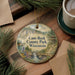 A decorative ornament featuring a scenic landscape of Cam-Rock County Park, Wisconsin, with pine trees and a waterfall.