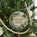 A Christmas tree decorated with ornaments, including a circular ornament with a scenic image of Camano Island, Washington.