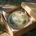 A decorative ornament in a wooden box, featuring a scenic landscape with a canoe and trees, with the text "Canoe-Picnic Point State Park New York" printed on it.