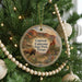 A circular ornament hanging on a Christmas tree, featuring a scenic image of Caprock Canyon State Park, Texas.