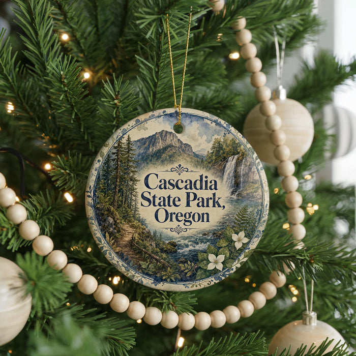 A Christmas tree decorated with ornaments, including a circular ornament with a scenic image of the Cascade State Park in Oregon.