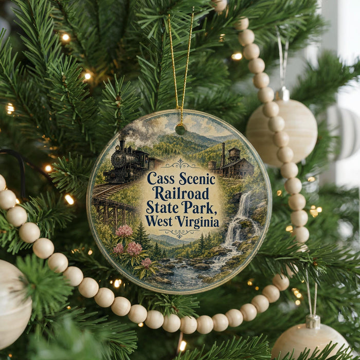 A Christmas tree ornament with a scenic image of a train and a waterfall, surrounded by greenery and beaded ornaments.