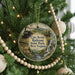 A Christmas tree ornament with a scenic image of a train and a waterfall, surrounded by greenery and beaded ornaments.