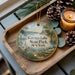 A decorative ornament featuring a scenic view of Cayuga Lake State Park in New York, with pine cones and a lit candle on a wooden tray.