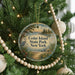 A round ornament hanging on a Christmas tree, featuring a scenic image of a lake and trees, with the text "Cedar Island State Park, New York" displayed on it.