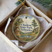 A round ornament with a scenic landscape of Chadron State Park, Nebraska, displayed in a box with a white tissue paper lining.