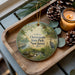 A decorative ornament featuring a scenic image of Chesequake State Park, New Jersey, with pine cones and a lit candle on a wooden tray.