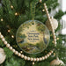 A round ornament hanging on a Christmas tree, featuring a scenic image of Cheesecake State Park in New Jersey.