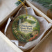 A decorative ornament in a box, featuring a scenic landscape with a waterfall, flowers, and a house, with the text "Chickasaw State Park, Tennessee" prominently displayed.