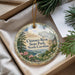A decorative ornament with a scenic landscape of Chimney Rock State Park, North Carolina, featuring a mountain, pine trees, and a river.