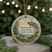 A decorative ornament featuring a scenic landscape with a cliff, trees, and mountains, with the text "Chimney Rock State Park, North Carolina" prominently displayed.