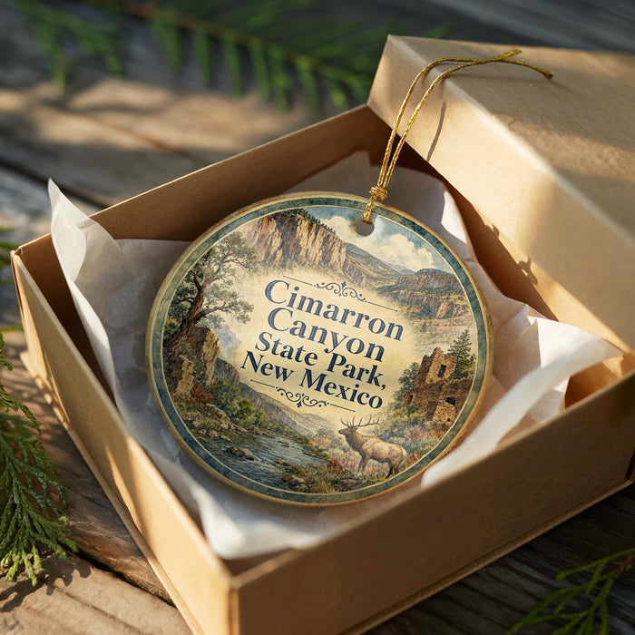 An oval-shaped ornament with a landscape scene and text, placed in a cardboard box with a gold string.
