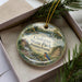 A decorative ornament in a box, featuring a scenic image of Codorus State Park in Pennsylvania.