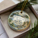 A decorative ornament in a box, featuring a scenic image of Cold Harbor State Park in New York.