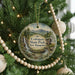 A round ornament hanging on a Christmas tree, featuring a scenic image of the Coleman State Park in New Hampshire.