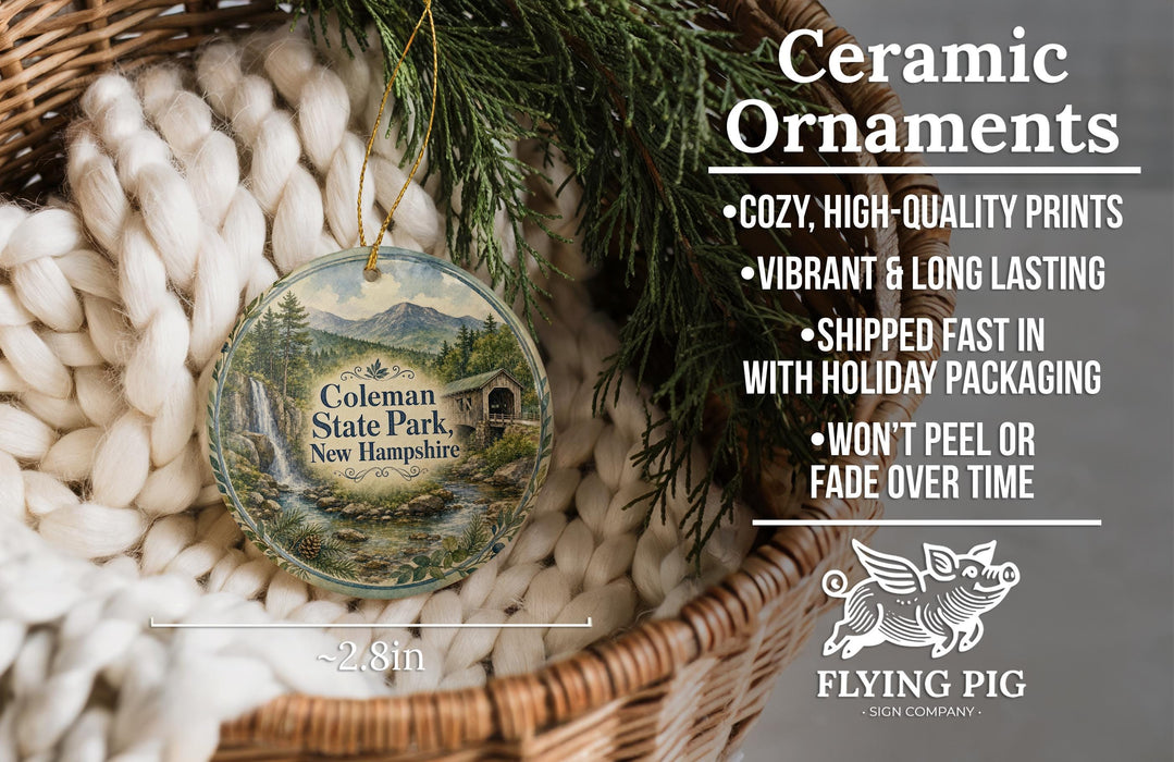 Ceramic ornaments, specifically those featuring the Colman State Park in New Hampshire, are displayed in a woven basket. The text highlights the ornaments as "cozy, high-quality prints" and "vibrant & long lasting", with a description of their shipping speed and packaging. The image also includes a logo for "Flying Pig - SIGN COMPANY".