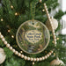 A round ornament hanging on a Christmas tree, featuring a scenic image of Coles Creek State Park in New York.