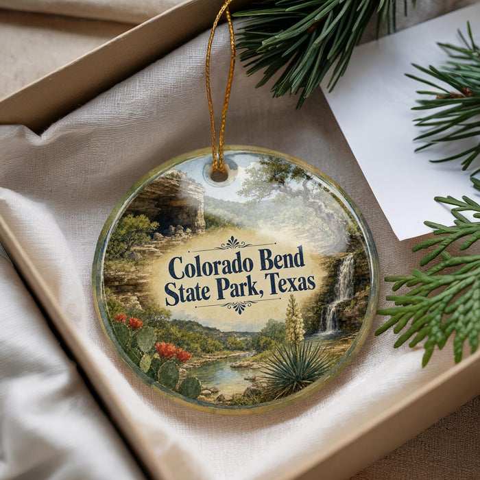 A decorative ornament with a scenic landscape of Colorado Bend State Park, Texas, featuring a waterfall, cactus, and other natural elements.
