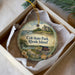 A decorative ornament in a box, featuring a scenic image of Colts State Park, Rhode Island, with a sailboat and a castle in the background.