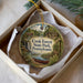 A circular ornament with a scenic illustration of Cook Forest State Park, Pennsylvania, hanging from a string.