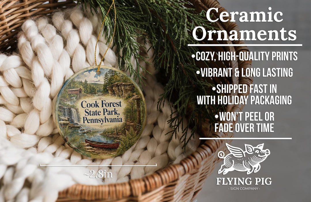 Ceramic ornaments, featuring a picture of Cook Forest State Park, Pennsylvania, hanging in a basket with pine branches.
