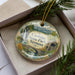A decorative ornament with a scenic landscape of Coolidge State Park, Vermont, featuring a waterfall, bridge, and mountains.