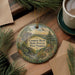 A decorative ornament featuring a scenic landscape of the Coopers Rock State Forest in West Virginia, with pine trees, a bridge, and a waterfall.