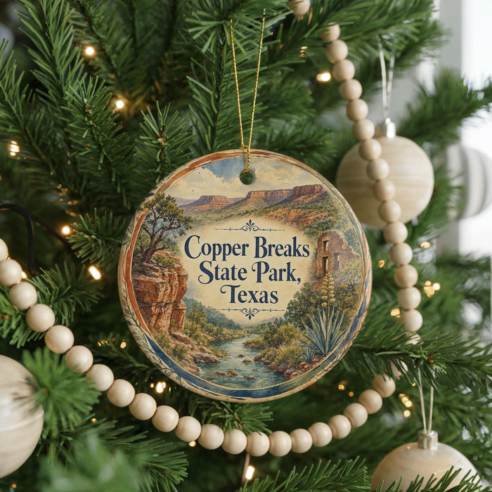 A Christmas tree decorated with ornaments, including a circular ornament with a scenic image of Copper Breaks State Park, Texas.