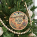 A round ornament hanging on a Christmas tree, featuring a scenic image of the Corall Pink Sand Dunes State Park in Utah.