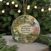 A round ornament featuring a portrait of a man, surrounded by a landscape scene with a house, trees, and a bridge.