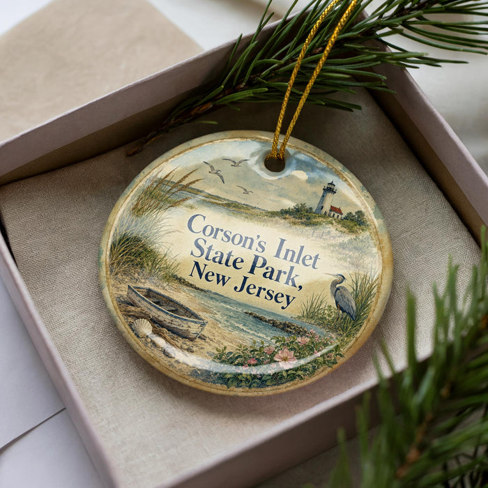 A decorative ornament in a box, featuring a lighthouse and a bird, with the text "Corson's Inlet State Park, New Jersey" printed on it.