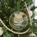 A round ornament hanging on a Christmas tree, featuring a scenic image of Cowan Lake State Park, Ohio.
