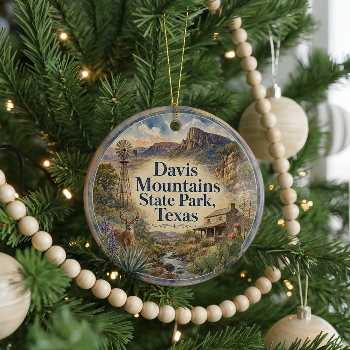 A round ornament hanging on a Christmas tree, featuring a scenic image of Davis Mountains State Park, Texas.