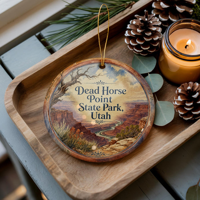A wooden tray with a decorative ornament featuring a scenic landscape of Dead Horse Point State Park, Utah, and pine cones.