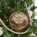 A circular ornament hanging on a Christmas tree, featuring a scenic image of the Dead Horse Point State Park in Utah.