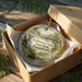 A decorative ornament in a box, featuring a scenic image of Delaware Canal State Park, Pennsylvania.