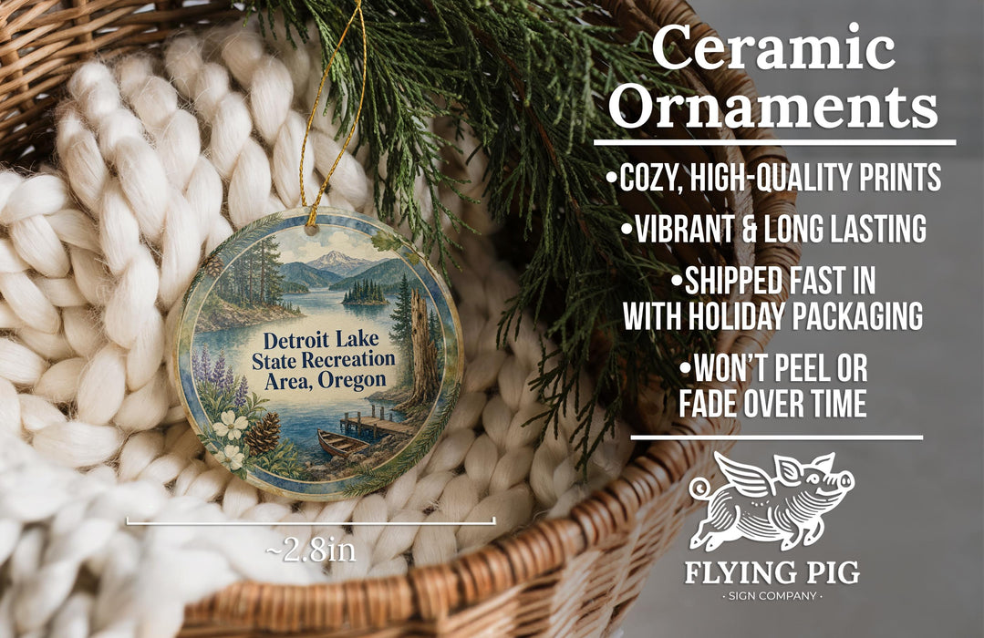 Ceramic ornaments, featuring a detailed image of a lake and mountains, are displayed in a basket. The text highlights the ornaments as "Ceramic Ornaments" and mentions their features such as "Cozy, high-quality prints", "Vibrant & long lasting", "Shipped fast in", "with holiday packaging", and "won't peel or fade over time". The image also includes a scale for size comparison and the logo of "Flying Pig - SIGN COMPANY".