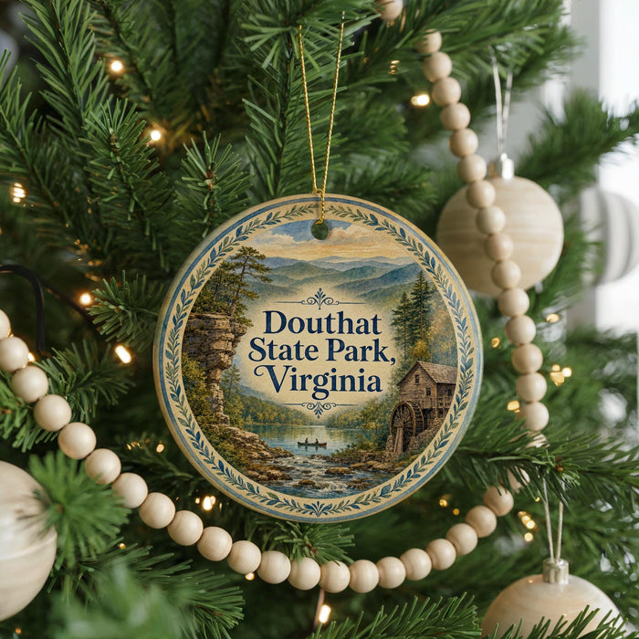 A round ornament hanging on a Christmas tree, featuring a scenic image of Douthat State Park, Virginia.