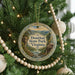A round ornament hanging on a Christmas tree, featuring a scenic image of Douthat State Park, Virginia.
