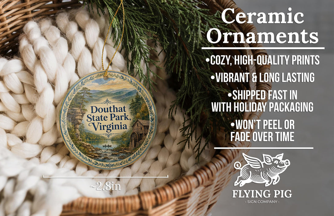 Ceramic ornaments, specifically Douthat State Park, Virginia ornaments, are displayed in a basket with pine branches.