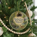 A circular ornament hanging on a Christmas tree, featuring a scenic image of Dunbar Cave State Park, Tennessee.