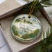 A decorative ornament with a lighthouse and a scenic landscape, featuring the text "East Harbor State Park, Ohio" on it.