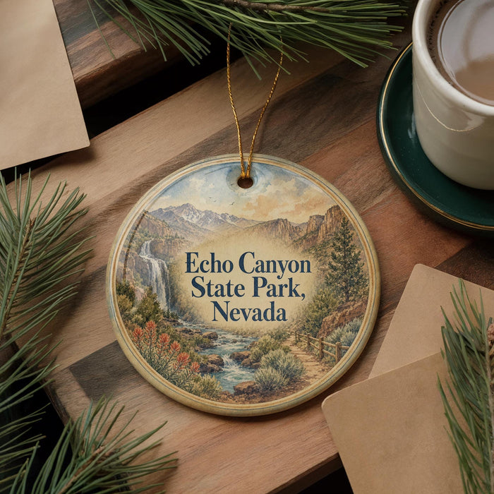 A decorative ornament featuring a scenic image of Echo Canyon State Park, Nevada, with a waterfall and mountains in the background. The ornament is hanging on a wooden surface, surrounded by pine branches and a cup of coffee.