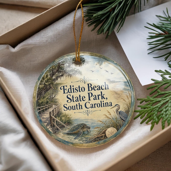 A decorative ornament with a beach scene and a bird, placed in a box with pine branches.