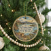 A circular ornament hanging on a Christmas tree, featuring a scenic image of El Vado Lake State Park, New Mexico.
