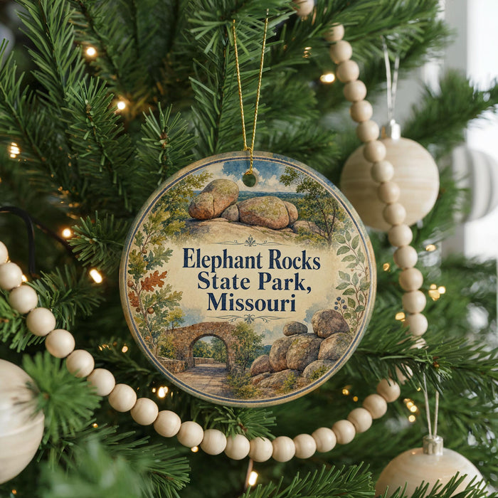 A round ornament hanging on a Christmas tree, featuring a scenic image of Elephant Rocks State Park, Missouri.