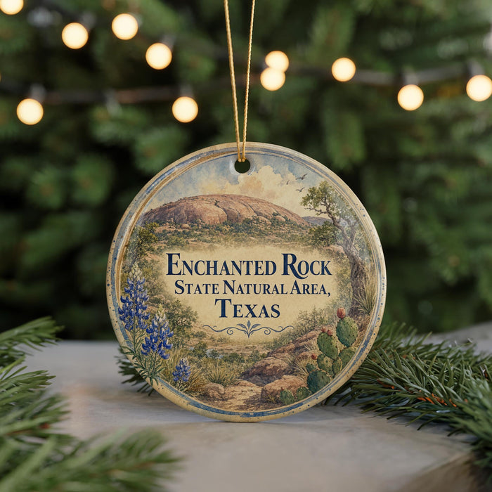 A circular ornament with a scenic image of a natural landscape, including a mountain, trees, and flowers, along with the text "Enchanted Rock State Natural Area, Texas".